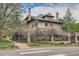 Street view of brick home featuring a wrought iron fence and mature trees at 680 N Emerson St, Denver, CO 80218