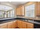 Kitchen with light wood cabinets, double sink, and window at 9543 Pearl Cir # 101, Parker, CO 80134