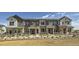 New townhome exteriors featuring a two-story design, stone accents, and manicured landscaping at 2018 S Haleyville Way, Aurora, CO 80018
