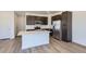 Kitchen featuring stainless steel appliances, quartz countertops, large center island, and dark wood cabinets at 2018 S Haleyville Way, Aurora, CO 80018
