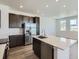 Kitchen featuring stainless steel appliances, quartz countertops, large center island, and dark wood cabinets at 2018 S Haleyville Way, Aurora, CO 80018