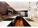 This kitchen features dark cabinets, stainless steel appliances, tile backsplash and hardwood floors at 3390 Cranston Cir, Highlands Ranch, CO 80126