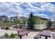 Community park featuring picnic tables, benches, a small structure, and lush greenery under a cloudy sky at 3390 Cranston Cir, Highlands Ranch, CO 80126