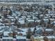 A snow-covered neighborhood with colorful homes, mature trees, and roads, as seen from an aerial perspective at 4053 S Riviera St, Aurora, CO 80018