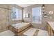 Relaxing bathroom with a tiled tub and natural light from two large windows at 4053 S Riviera St, Aurora, CO 80018