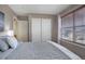 Bedroom featuring a large window and sliding door closet at 4053 S Riviera St, Aurora, CO 80018