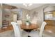 Bright dining area with a round wood table, four upholstered chairs, and decor, open to the kitchen at 4053 S Riviera St, Aurora, CO 80018