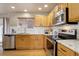 Modern kitchen featuring stainless steel appliances, granite countertops, white subway backsplash, and wooden cabinets at 4053 S Riviera St, Aurora, CO 80018