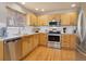 Well-lit kitchen featuring stainless steel appliances, granite countertops, and wooden cabinets at 4053 S Riviera St, Aurora, CO 80018