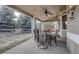 Covered patio features an outdoor dining set with views of the treed backyard at 4053 S Riviera St, Aurora, CO 80018