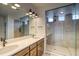 Modern bathroom featuring double sinks, wood cabinets, and a glass shower with rain showerhead at 23909 E 41St Ave, Aurora, CO 80019