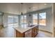 Open concept kitchen with a large island, stainless steel dishwasher, pendant lights, and hardwood floors at 23909 E 41St Ave, Aurora, CO 80019