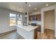 Bright kitchen with an island, modern stainless steel appliances, wooden cabinets, pendant lights, and lots of natural light at 23909 E 41St Ave, Aurora, CO 80019
