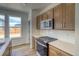 Well-lit kitchen featuring wooden cabinets, stainless steel appliances, modern gas stove, and attractive backsplash at 23909 E 41St Ave, Aurora, CO 80019