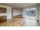 Spacious open-concept living area with hardwood floors, access to the backyard via a sliding glass door, and bright white walls at 23909 E 41St Ave, Aurora, CO 80019