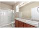 Bright bathroom featuring a double vanity, framed mirror, and glass-enclosed shower at 10266 Stagecoach Ave, Firestone, CO 80504