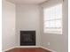 Bright living room nook featuring dark hardwood floors, a window with blinds, and fireplace at 10266 Stagecoach Ave, Firestone, CO 80504