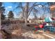 Spacious backyard with a mature tree, patio furniture, and a fenced perimeter at 3023 S Fenton St, Denver, CO 80227