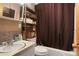 Cozy bathroom with a shower/tub combo, updated vanity and a shelf for towels at 3023 S Fenton St, Denver, CO 80227