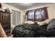 Dark bedroom with fur throw, dark furniture and window with curtains at 3023 S Fenton St, Denver, CO 80227