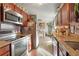 Galley kitchen featuring wood cabinets, stainless steel appliances, and granite countertops at 3023 S Fenton St, Denver, CO 80227