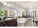 Bright, open bathroom featuring a double sink vanity, standalone tub, walk-in shower and large window at 6370 Twilight Ave, Firestone, CO 80504