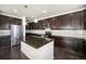 Spacious kitchen with an island, dark cabinetry, stainless steel appliances, and hardwood floors at 6370 Twilight Ave, Firestone, CO 80504