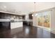 Stylish kitchen featuring dark cabinets, stainless steel appliances, and an open layout with hardwood floors at 6370 Twilight Ave, Firestone, CO 80504