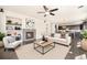 Bright living room featuring a fireplace, built in shelves, ceiling fan, and view of the eat-in kitchen at 6370 Twilight Ave, Firestone, CO 80504