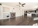 Open living room featuring a fireplace, built-in shelving, and hardwood floors that seamlessly connect to the kitchen at 6370 Twilight Ave, Firestone, CO 80504