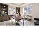Bright office featuring custom wood shelving, lots of natural light, and a modern office desk and chair at 6370 Twilight Ave, Firestone, CO 80504