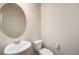 Cozy powder room features a pedestal sink, an oval mirror, and a standard toilet at 6370 Twilight Ave, Firestone, CO 80504