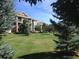 Well-maintained building with beautiful landscaping, green grass, and trees at 804 Summer Hawk Dr # 6105, Longmont, CO 80504