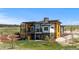 Modern home with large windows and a balcony surrounded by a large yard on a sunny day at 11115 Evening Hunt Rd, Franktown, CO 80116