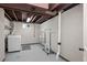 Unfinished basement area featuring laundry machines and shelving unit for ample storage opportunities at 1765 S Endicott St, Lakewood, CO 80232