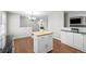 Eat-in kitchen with hardwood flooring, dining area, island, and updated appliances at 1765 S Endicott St, Lakewood, CO 80232