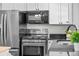 Modern kitchen featuring stainless steel appliances, black countertops, and white cabinets at 1765 S Endicott St, Lakewood, CO 80232