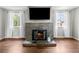 Cozy living room with stone fireplace, mantle, and large windows offering natural light at 1765 S Endicott St, Lakewood, CO 80232