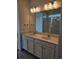 Double vanity bathroom with a large mirror and modern light fixtures at 498 Grey Rock St, Brighton, CO 80601