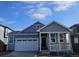 Gray exterior of charming craftsman style home with white trim and a two-car garage at 498 Grey Rock St, Brighton, CO 80601