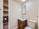 Bathroom with a dark wood vanity, large mirror, and open shelving at 2446 S Vaughn Way # A, Aurora, CO 80014