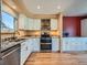 Bright kitchen featuring white cabinets, stainless steel appliances, granite countertops, and hardwood floors at 2446 S Vaughn Way # A, Aurora, CO 80014