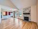 Open living room with a stone fireplace, wood floors, and sliding doors leading to the outdoor deck at 2446 S Vaughn Way # A, Aurora, CO 80014