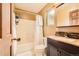 Bathroom with dark-wood vanity, large mirror, shower/tub combo, and white tile at 4 Virginia St, Idaho Springs, CO 80452
