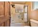 Bright bathroom featuring a shower-tub combo with sliding glass doors and white tile surround at 4 Virginia St, Idaho Springs, CO 80452