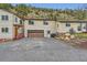 View of the exterior of the home featuring a gravel driveway and a brown two car garage at 4 Virginia St, Idaho Springs, CO 80452