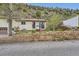 Ranch home featuring a landscaped yard and a retaining wall at 4 Virginia St, Idaho Springs, CO 80452