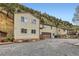 Spacious home featuring a two-car garage, gravel driveway, and a hillside backdrop at 4 Virginia St, Idaho Springs, CO 80452