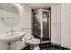 Modern bathroom with pedestal sink, glass-enclosed shower, and sleek black tile at 7000 E Quincy Ave # 317, Denver, CO 80237