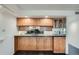 Cozy kitchen featuring oak cabinets and sleek black countertops at 7000 E Quincy Ave # 317, Denver, CO 80237